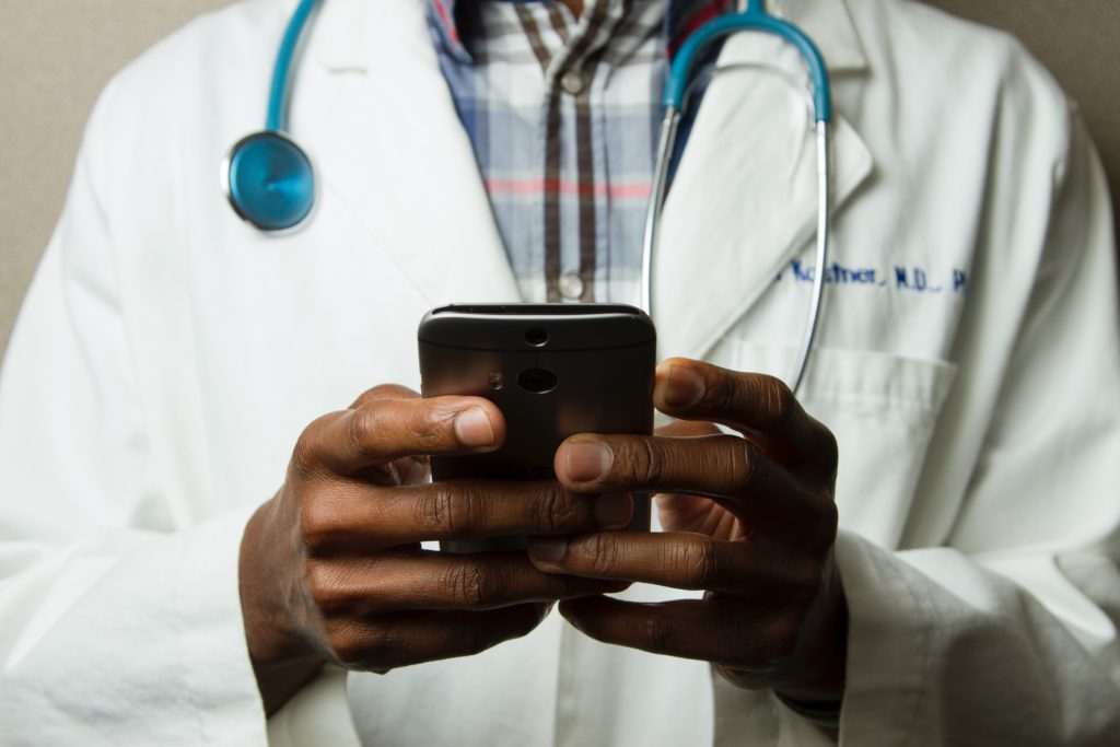 Doctor using digital technologies to deliver health care